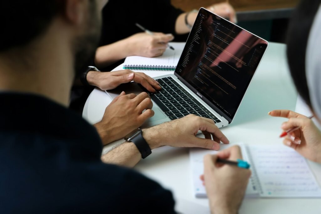 Equipo de ventas reunido alrededor de un portátil